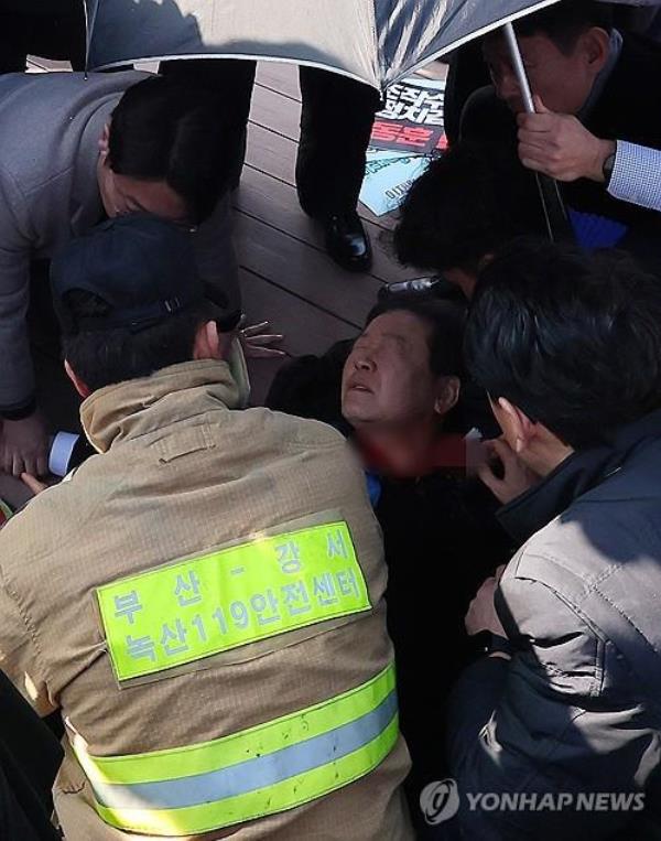 Opposition leader Lee Jae-myung is being treated while waiting for an ambulance after he was stabbed in the neck during a visit to the southeastern port city of Busan on Jan. 2, 2024. (Yonhap)
