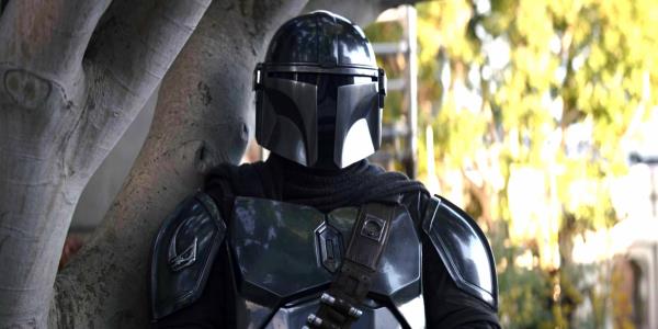 Din Djarin leans against a tree on Nevarro in The Mandalorian season 3