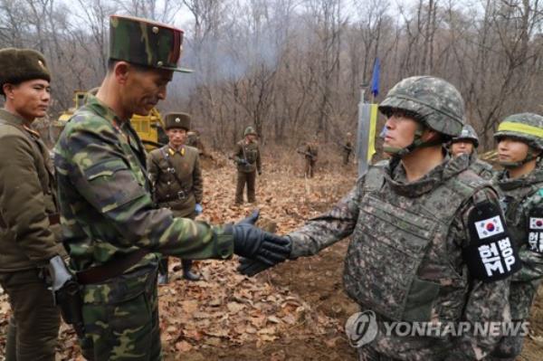 A South Korean military official (R) shakes hands with his North Korean counterpart as they meet inside the Demilitarized Zone separating the two Koreas to take part in a project to establish a cross-border road, in this file photo provided by Seoul's defense ministry on Nov. 22, 2018. (PHOTO NOT FOR SALE) (Yonhap)