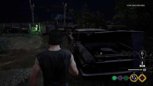 Johnny looks at the car battery in a run down car, which powers an electric barrier to a gate.