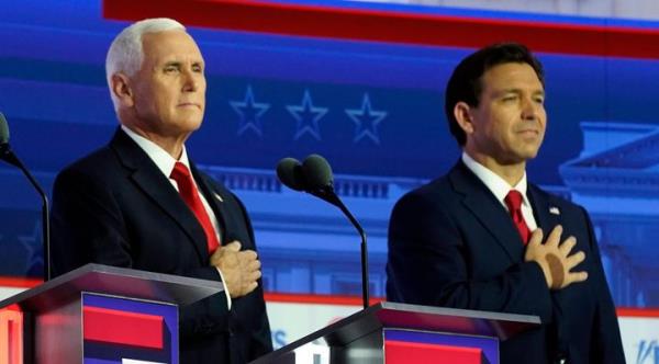 Republican presidential candidates former Vice President Mike Pence and Florida Gov. Ron DeSantis stand on stage before a Republican presidential primary debate on Wednesday, Aug. 23, 2023, in Milwaukee.