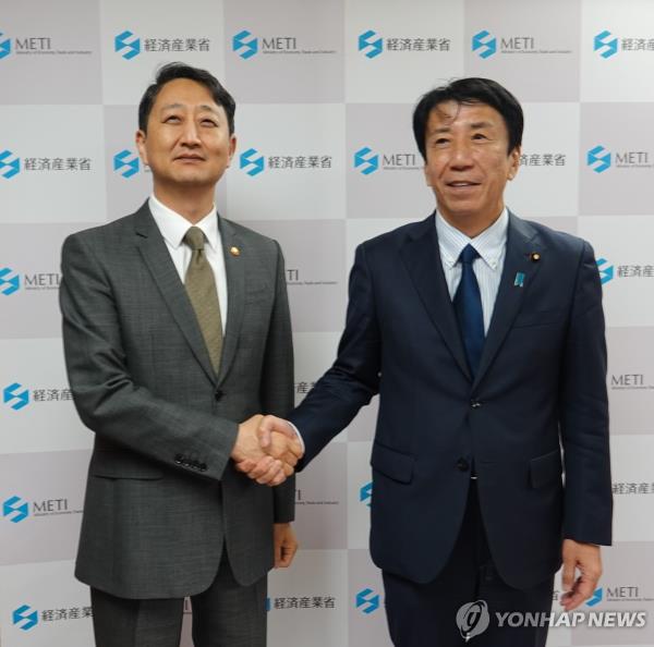 South Korean Industry Minister Ahn Duk-geun (L) shakes hands with his Japanese counterpart, Ken Saito, ahead of talks in Tokyo on April 22, 2024. (Yonhap)
