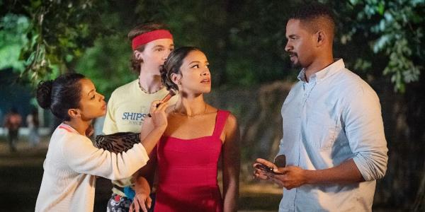 Gina Rodriguez as Mack getting makeup put on her in Players while looking at Damon Wayans Jr's Adam