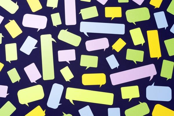 Differently colored paper speech bubbles against navy blue background