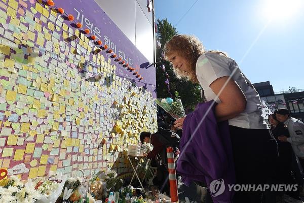 A bereaved family member of a victim of the Itaewon crowd crush lays flowers at a memorial space for the victims at the site of the tragedy in Itaewon, Seoul, in this Oct. 29, 2023, file photo. (Yonhap)